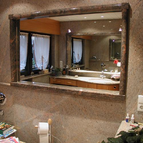 Ein Rahmen mit Ablagefläche aus Himalaya Granit um einen Spiegel. Die Wände sind aus Tropical Apricot Granit.