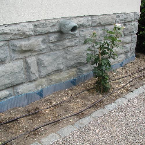 Fassade aus grob behauenen Quarzit mit einem Wasserspeier aus Anröchter Dolomit.