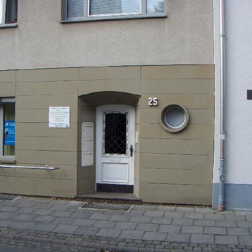 Fassade aus grauem Weser Sandstein mit einer vertieft angebrachter, oben abgerundeten Tür