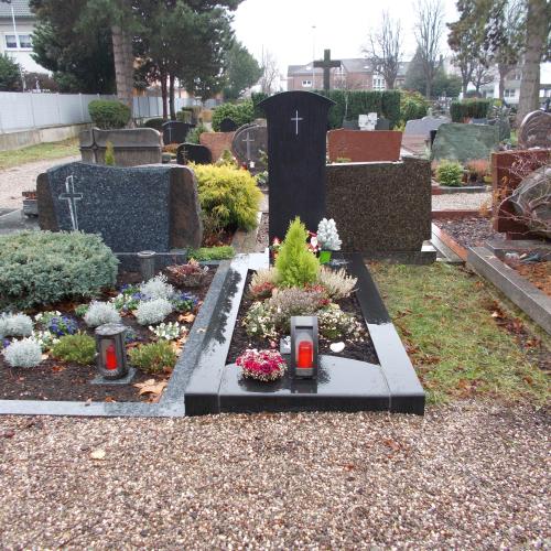 Eine schmale Stele mit Einfassung aus Indian Impala die sich an der Spitze fächerförmig verbreitet.