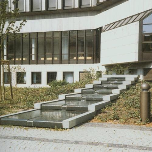 Der Fertiggestellte Brunnen 'Die sieben Stufen der Weisheit' vor dem Justizgebäude in Bielefeld