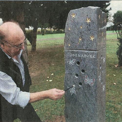 Der Seniorchef Richard Neff erlärt die Klangstäbe im Denkmal